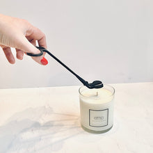 Load image into Gallery viewer, emo trimming a candle wick with wick trimmer