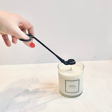 Load image into Gallery viewer, emo trimming a candle wick with wick trimmer
